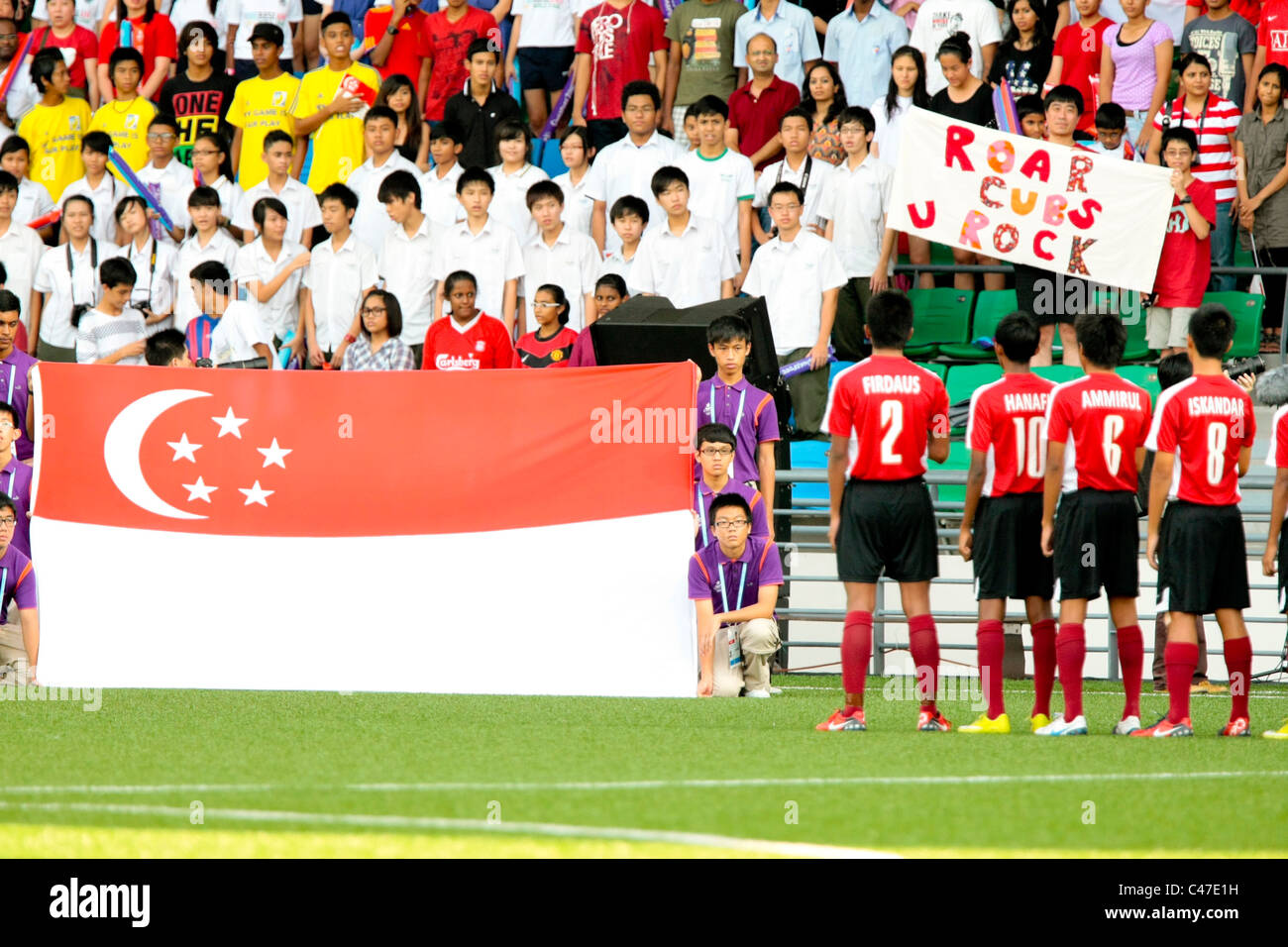 I giocatori di Singapore (destra) cantare il loro inno nazionale appena prima dell'inizio di uomini del calcio 3 ° posto playoff. Foto Stock