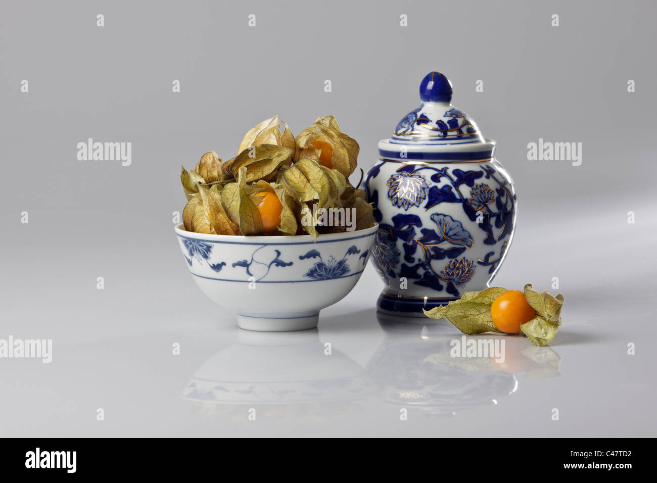 Studio shot di ribes del capo (physalis peruviana) cinese con ciotola e lidded pot. Foto Stock