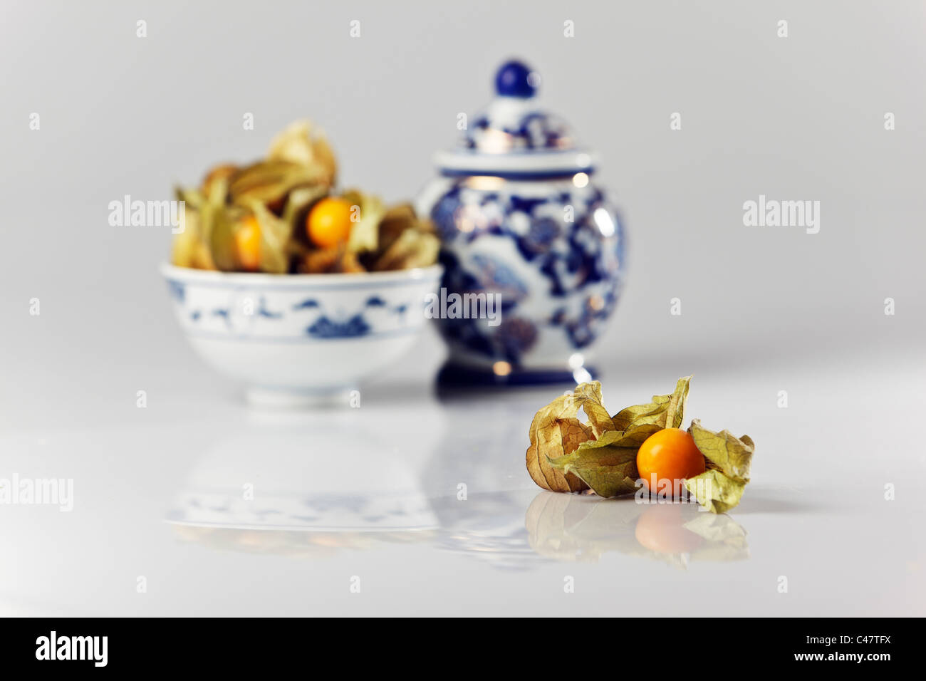 Studio shot di ribes del capo (physalis peruviana) cinese con ciotola e lidded pot. Foto Stock