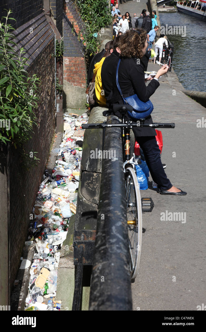 Spazzatura accanto ad una parete per il mercato di Camden, con persone mangiare seduti sulla parete Foto Stock