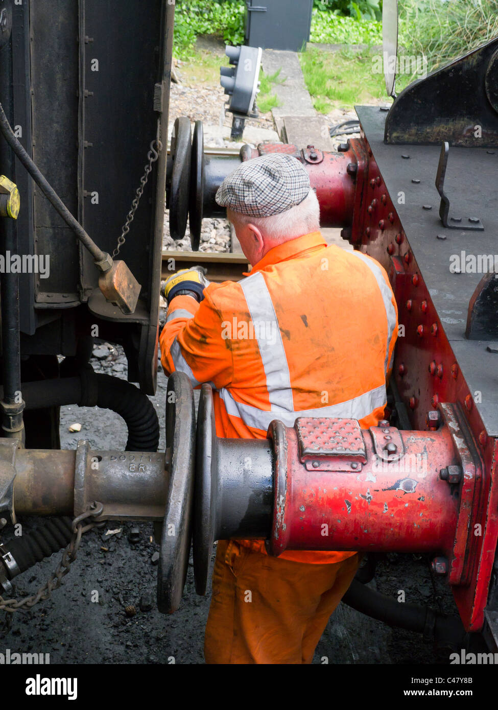 Un lavoratore su metà Hants linea ferroviaria collega i sistemi di due carrelli mentre a Leamington Spa stazione sulla linea di crescione. Foto Stock