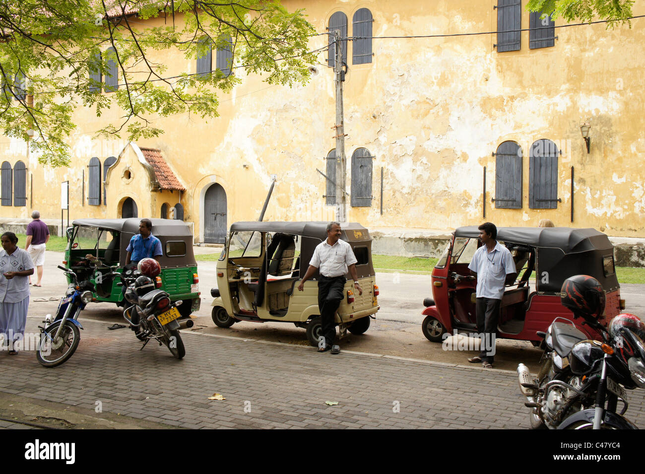 Un Tuk Tuk o auto rickshaw conducente in attesa per i clienti presso lo storico Forte di Galle, Sri Lanka Foto Stock