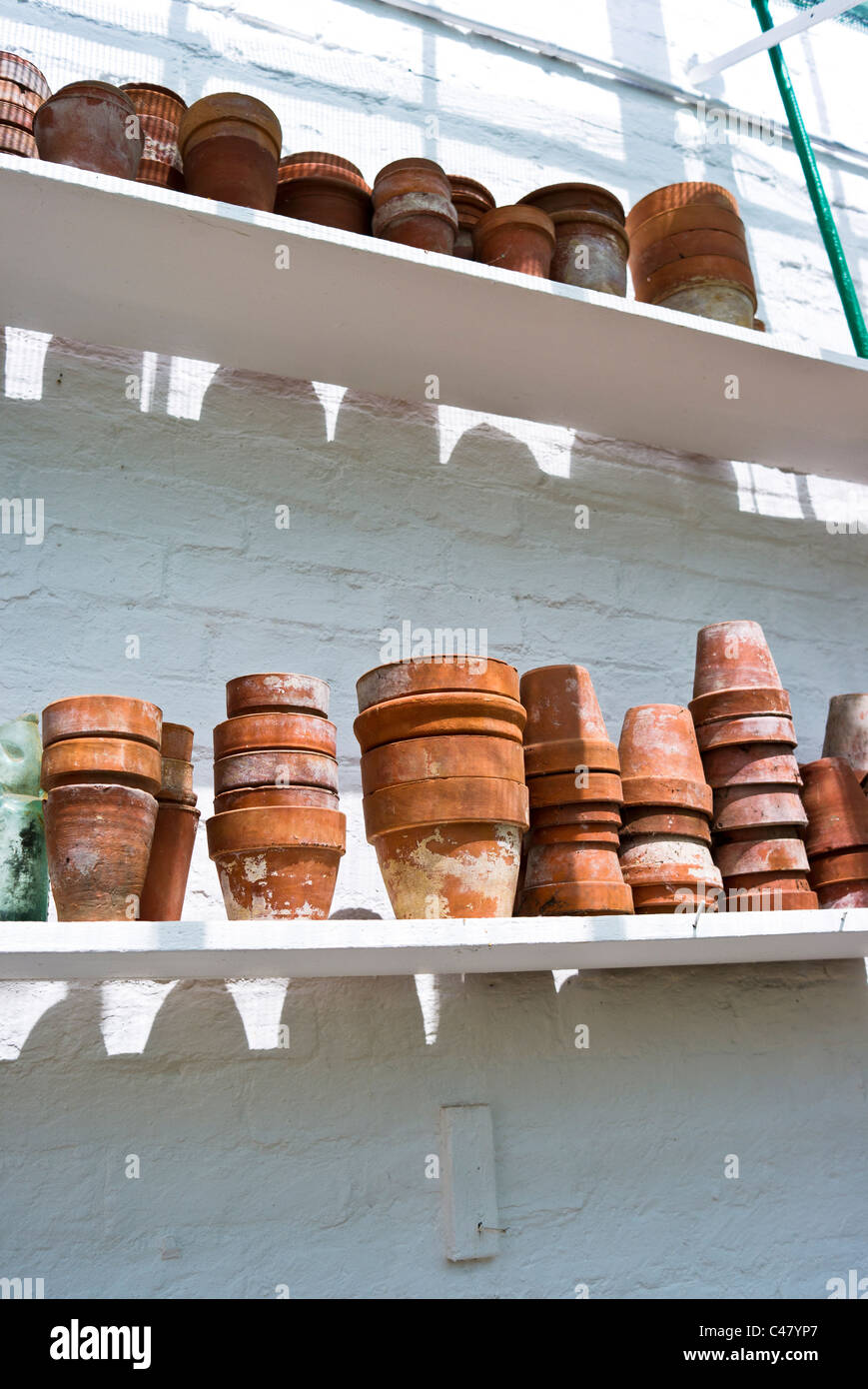 Vecchi vasi di terracotta su scaffali in vittoriano ristrutturato serra nel Regno Unito Foto Stock