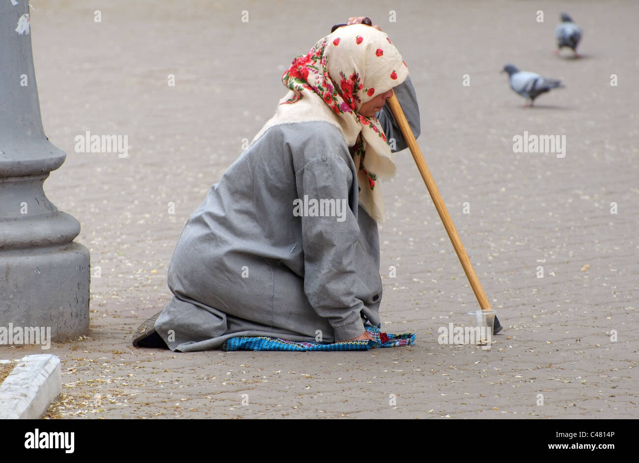 Una vecchia donna mendicando elemosina in strada Foto Stock