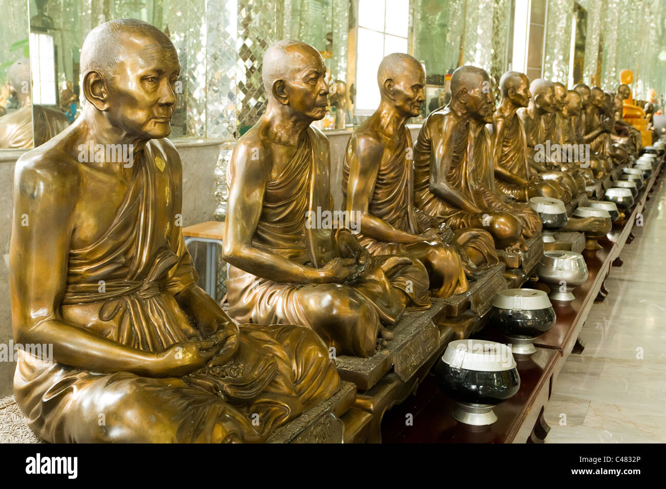 Fila di monaco golden statue buddiste in Viharn Kaew tempio di cristallo, angthong, Thailandia Foto Stock