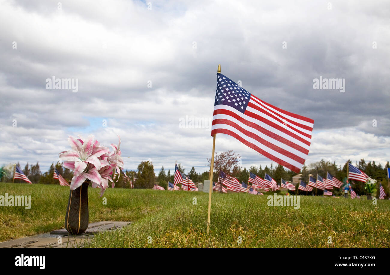 Bandierine americane e fiori volare su un cimitero del Memorial Day Foto Stock