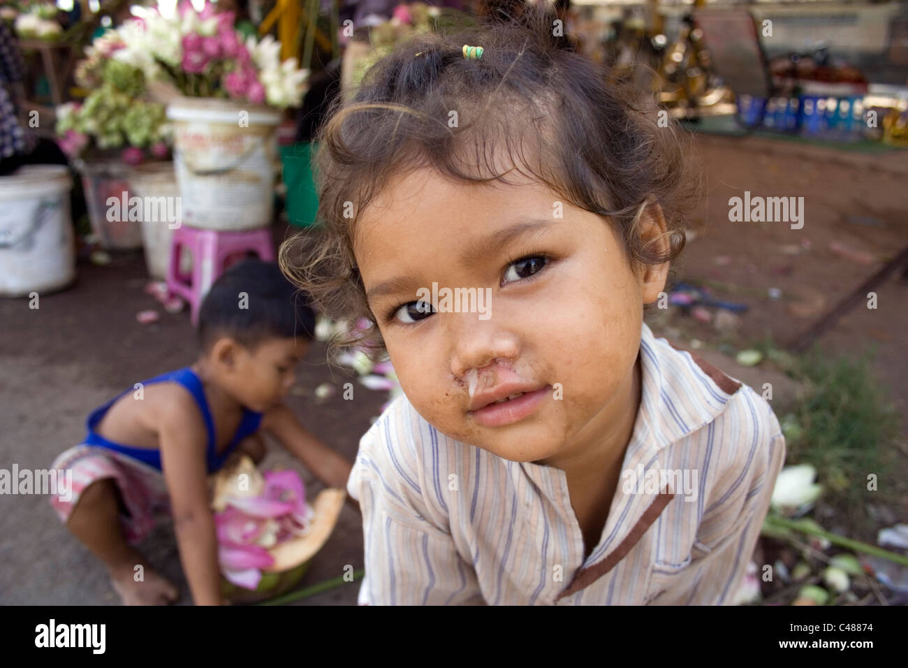 Una piccola ragazza cambogiano guarda nella lente della fotocamera Foto Stock