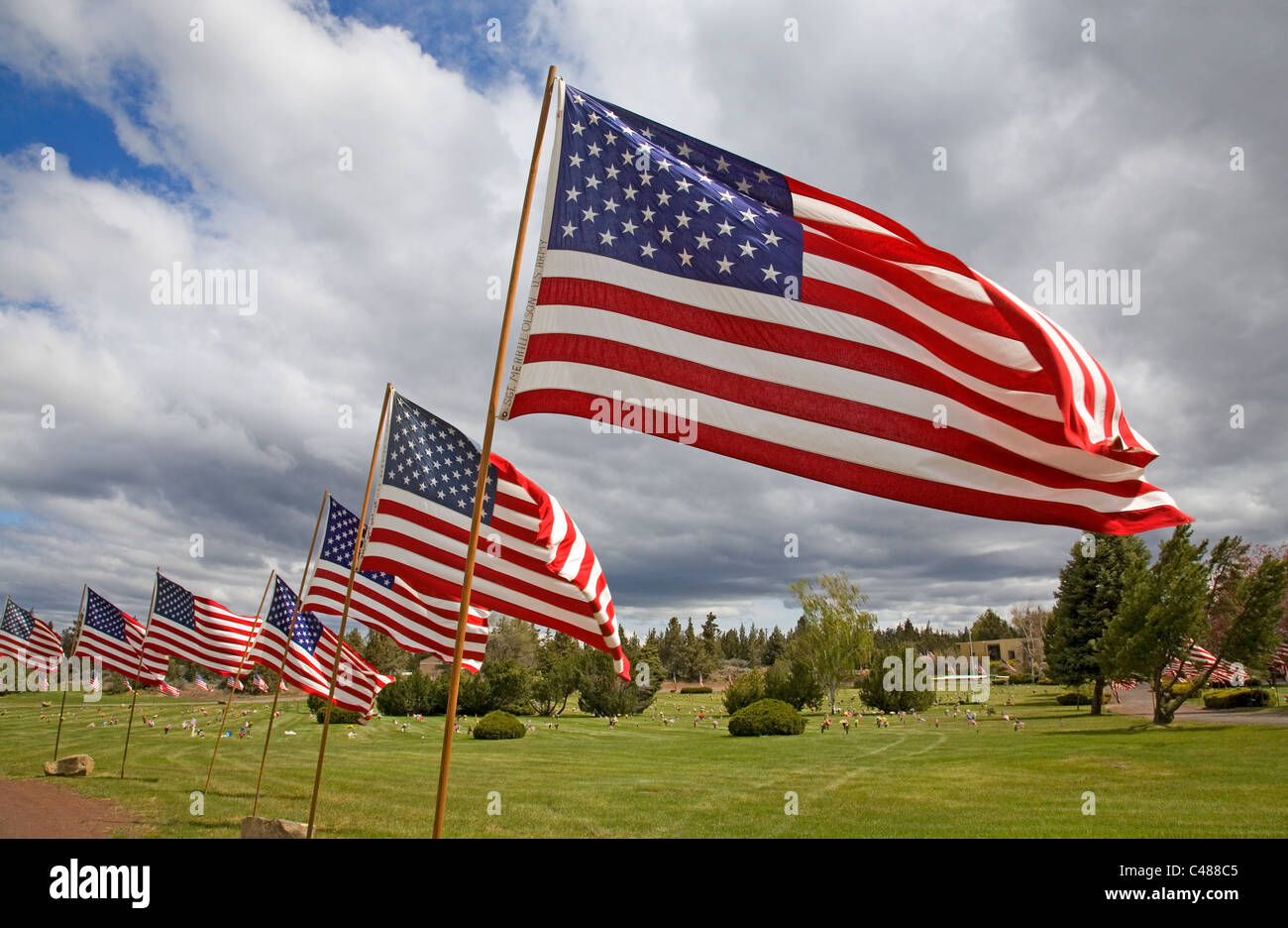 Bandierine americane e fiori volare su un cimitero del Memorial Day Foto Stock