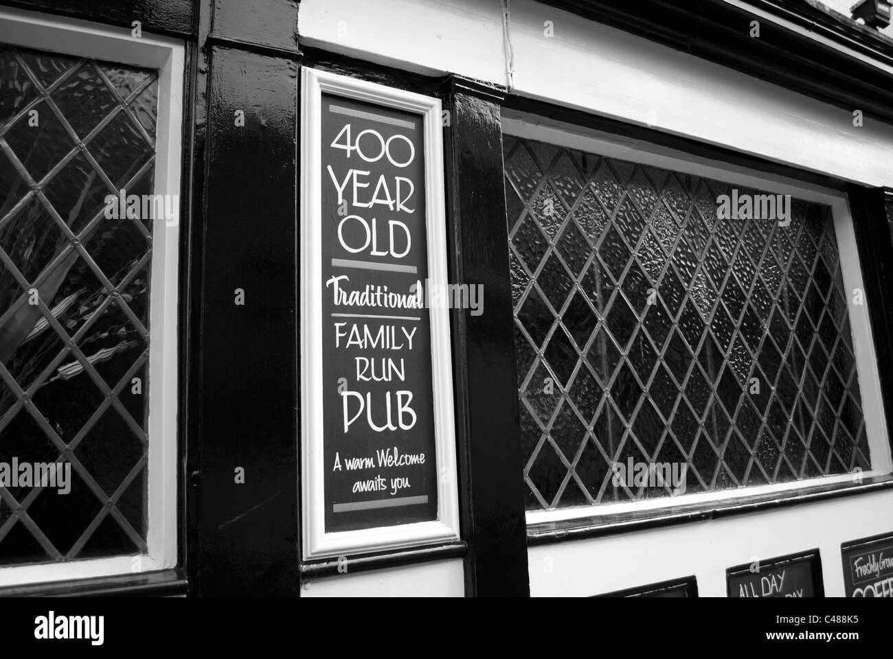 Finestra di pub e segno di 400 anno vecchio pub in bianco e nero e bianco edificio Foto Stock