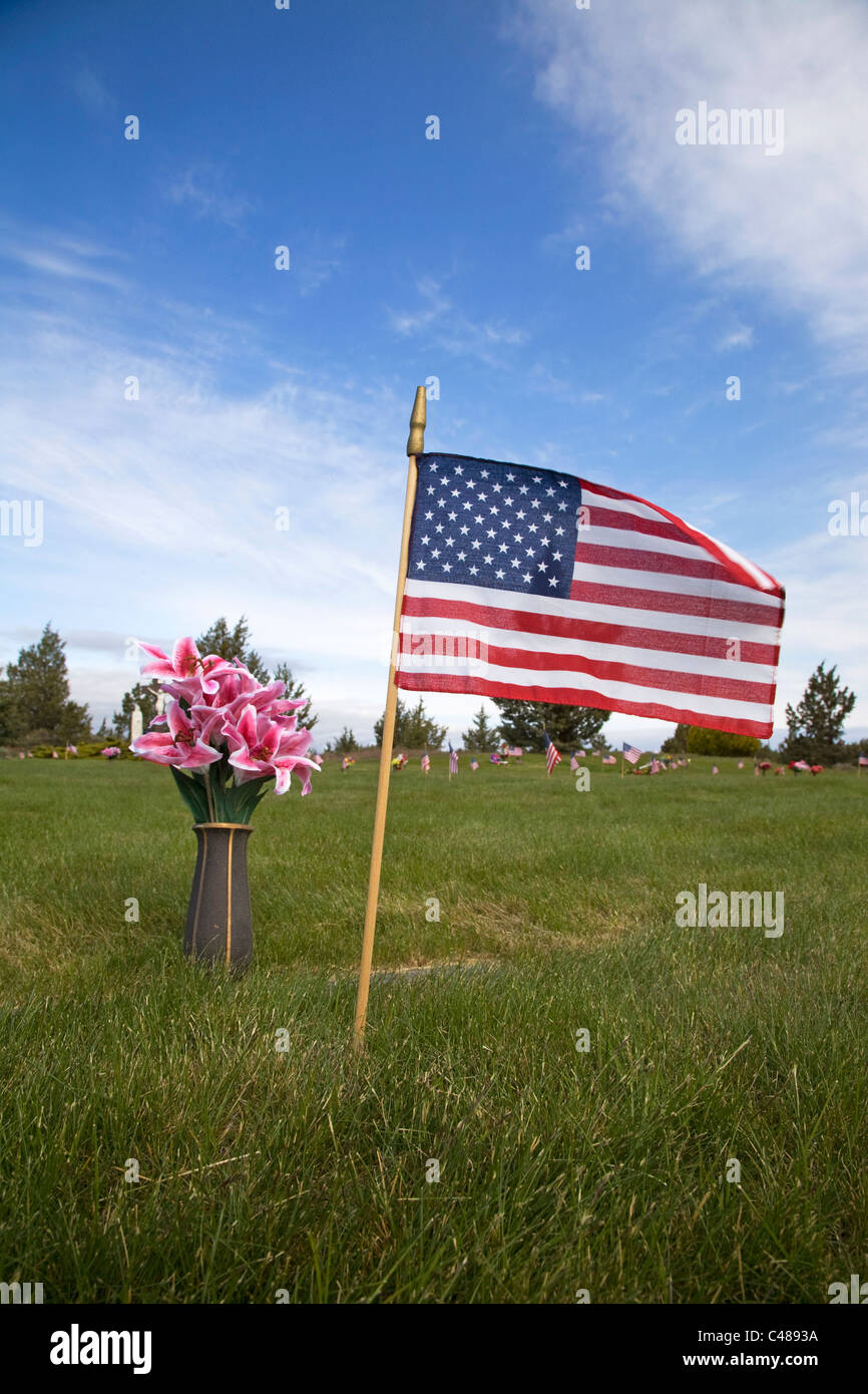 Bandierine americane e fiori volare su un cimitero del Memorial Day Foto Stock