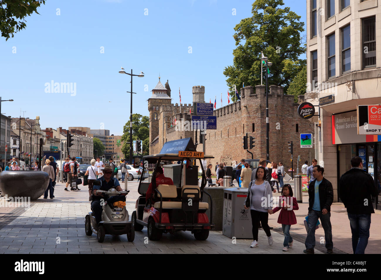 Queen Street, Cardiff, con disabilità il trasporto, e il Castello di Cardiff in background Foto Stock