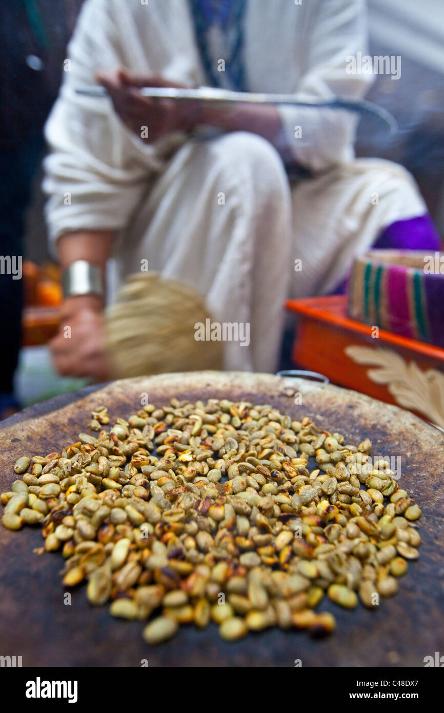 La donna la tostatura i chicchi di caffè durante una cerimonia del caffè in Etiopia ad Addis Abeba Foto Stock