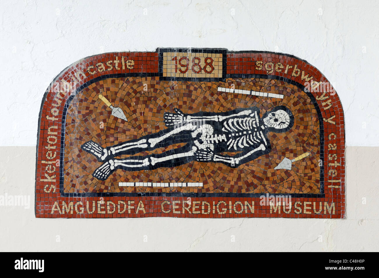 Uno di una serie di 8 set di mosaici nella parete intorno a Aberystwyth Castle, questo uno raffigurante lo scheletro trovato nel 1988. Foto Stock