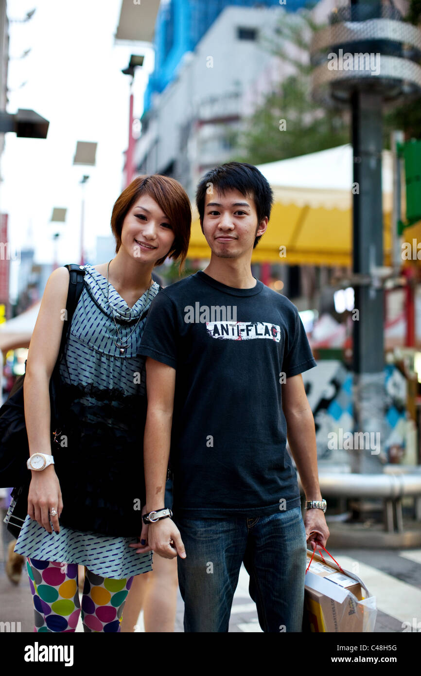 Ritratto di una giovane coppia in corrispondenza di un incrocio occupato di Ximending, Taipei, Taiwan, 24 ottobre 2010. Foto Stock