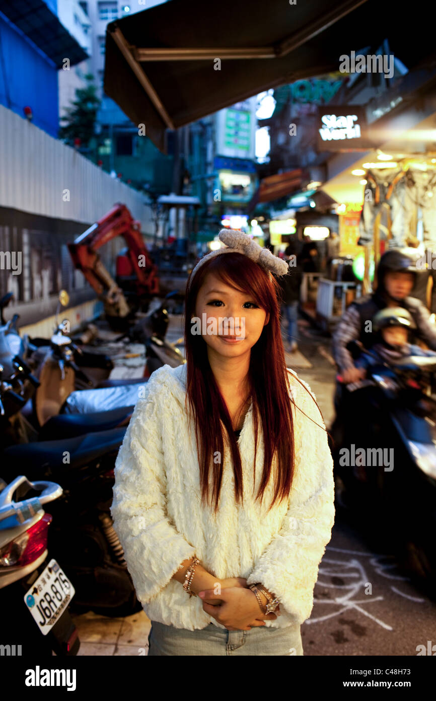 Ritratto di una ragazza adolescente al di fuori del negozio di abbigliamento dove lavora in Ximending, Taipei, Taiwan, Ottobre 29, 2010 Foto Stock