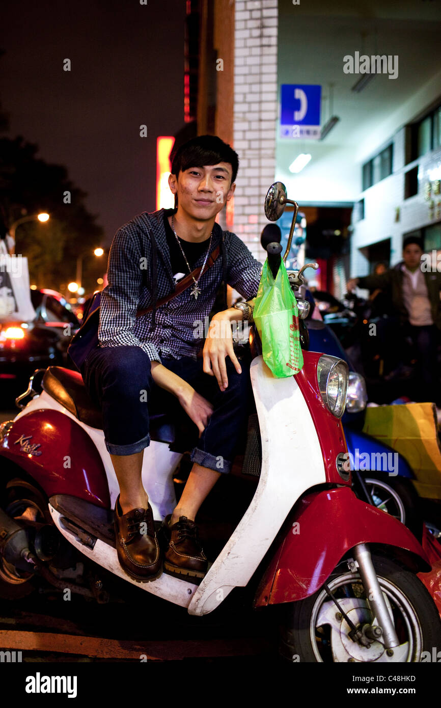 Ritratto di un giovane uomo sul suo scooter al Shida strada del mercato notturno, Taipei, Taiwan, 7 novembre 2010. Foto Stock