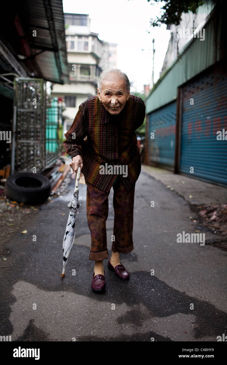 Una donna anziana fuori per una passeggiata mattutina, Taipei, Taiwan, Ottobre 29, 2010. Foto Stock