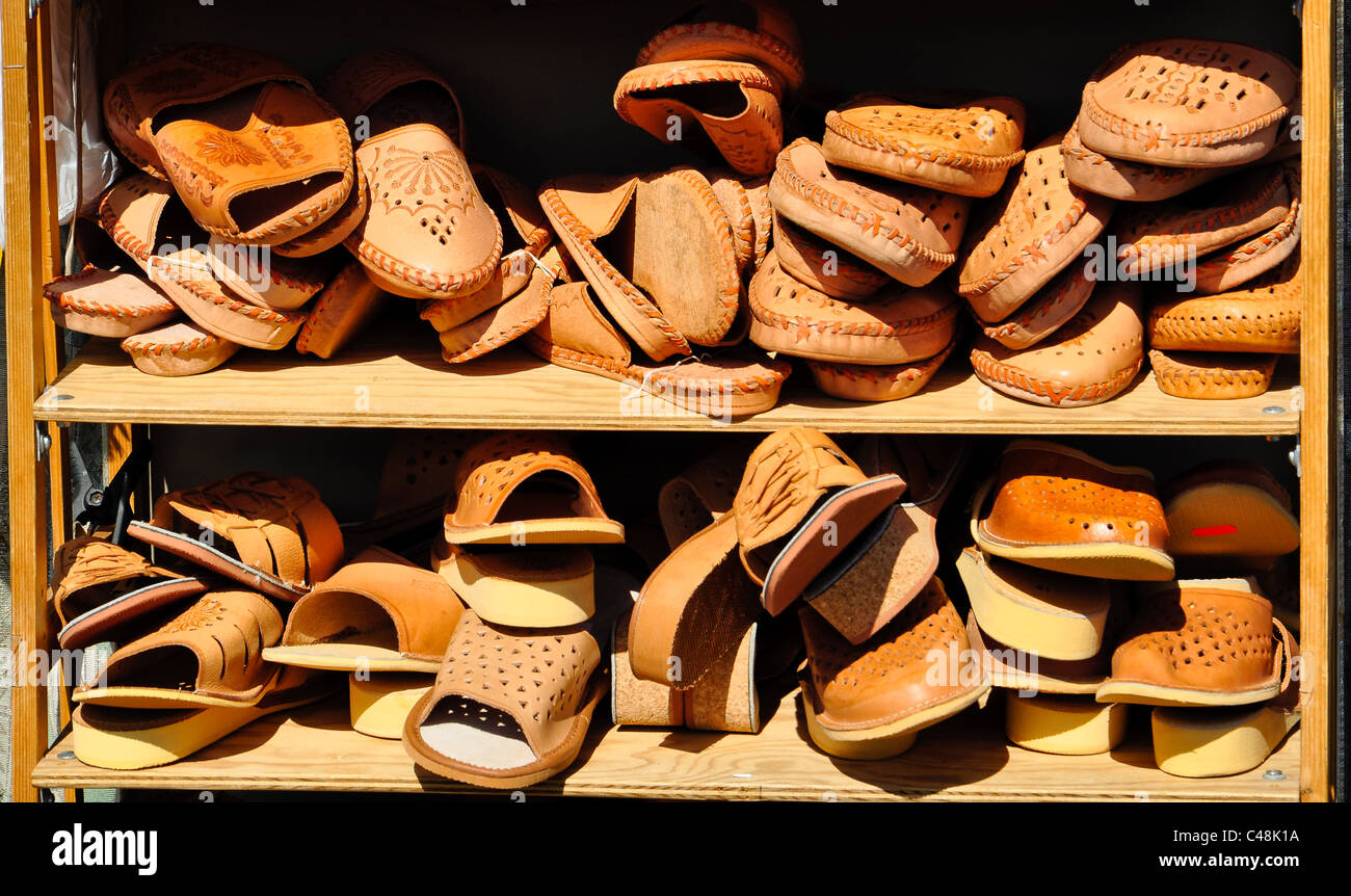 Rack popolato con pelle marrone scarpe e sandali su un mercato Foto Stock