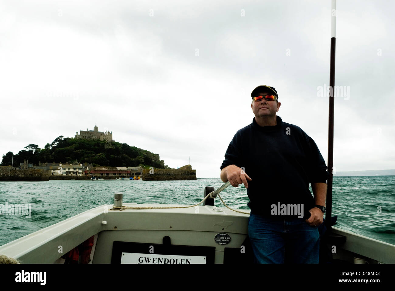 Il capitano del traghetto e barca lasciando St Michaels Mount, Cornwall Inghilterra REGNO UNITO Foto Stock