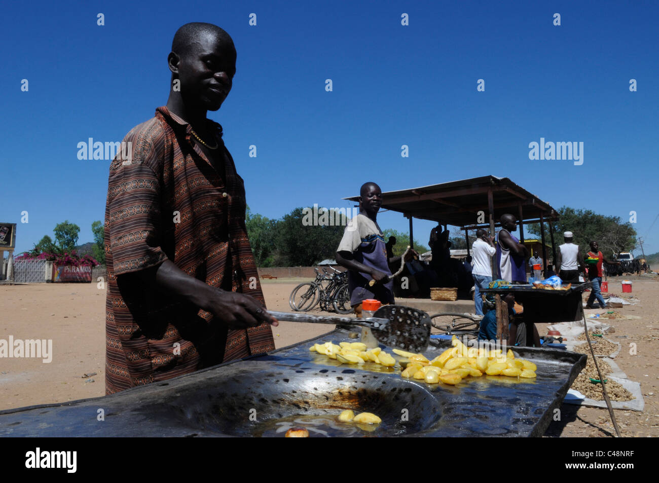 Un venditore friggitrice di patate in un carrello alimentare in Malawi Africa centrale Foto Stock