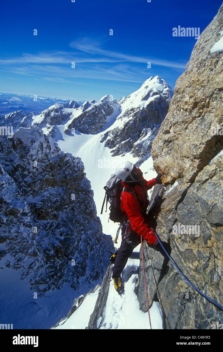 Un uomo prevede la sua prossima mossa mentre si arrampica nel Teton Range, Grand Teton National Park, Wyoming. Foto Stock