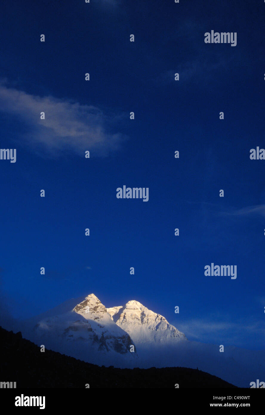 Un massiccio coperto di neve brilla di montagna con bagliore alpino al tramonto. Foto Stock