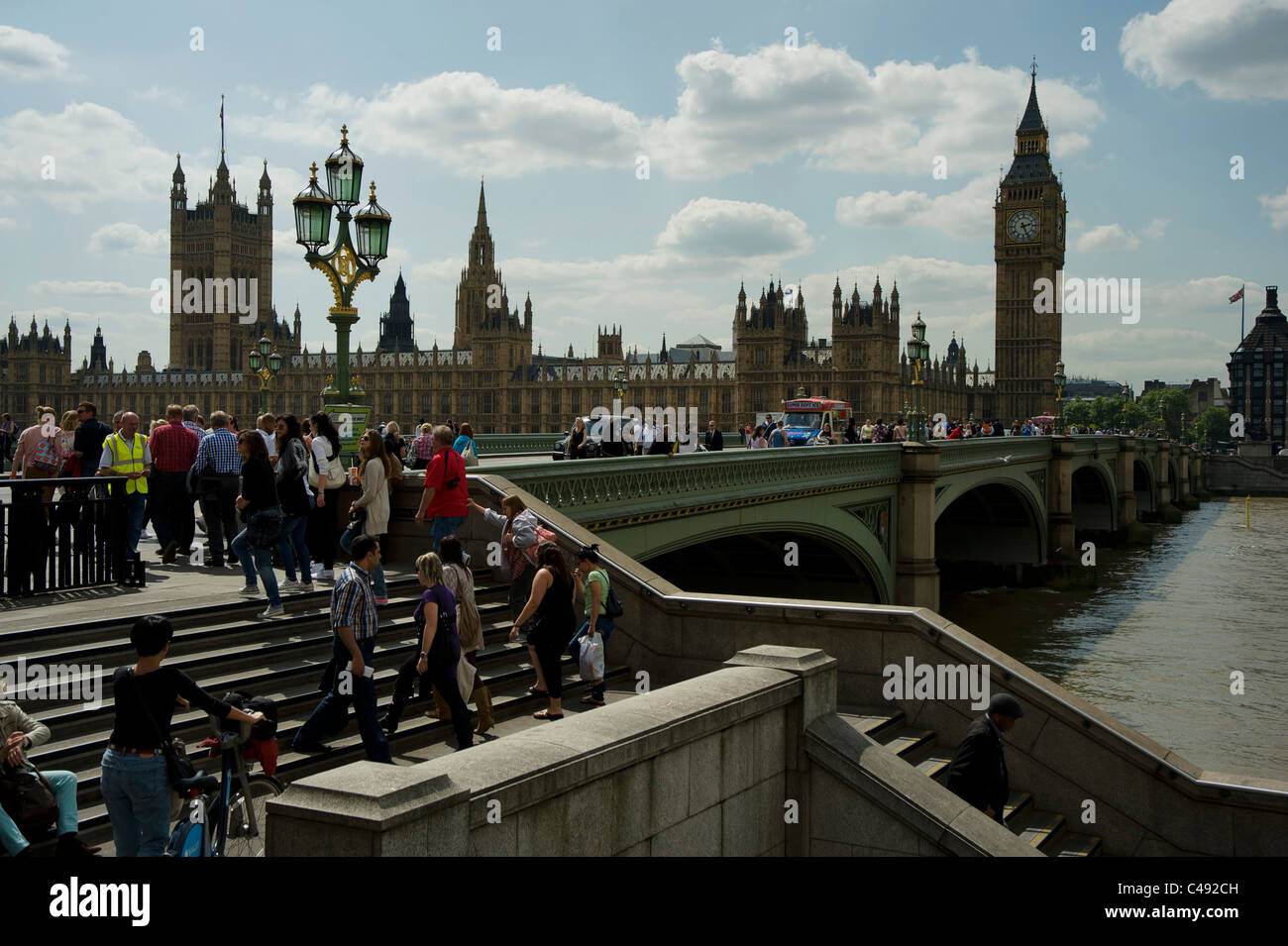 I turisti sul Westminster Bridge, con le case del Parlamento in background. Foto Stock