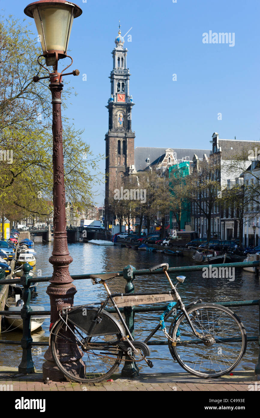 Bicicletta sul ponte sul canale Prinsengracht con torre di Westerkerk (Westertoren) dietro, Grachtengordel, Amsterdam, Paesi Bassi Foto Stock