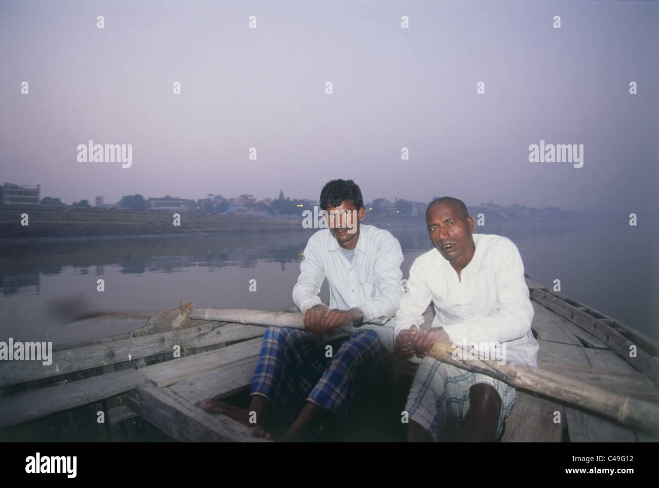 Fotografia dei due uomini indiano canottaggio la loro barca sulle rive di un fiume in Varanasi India Foto Stock