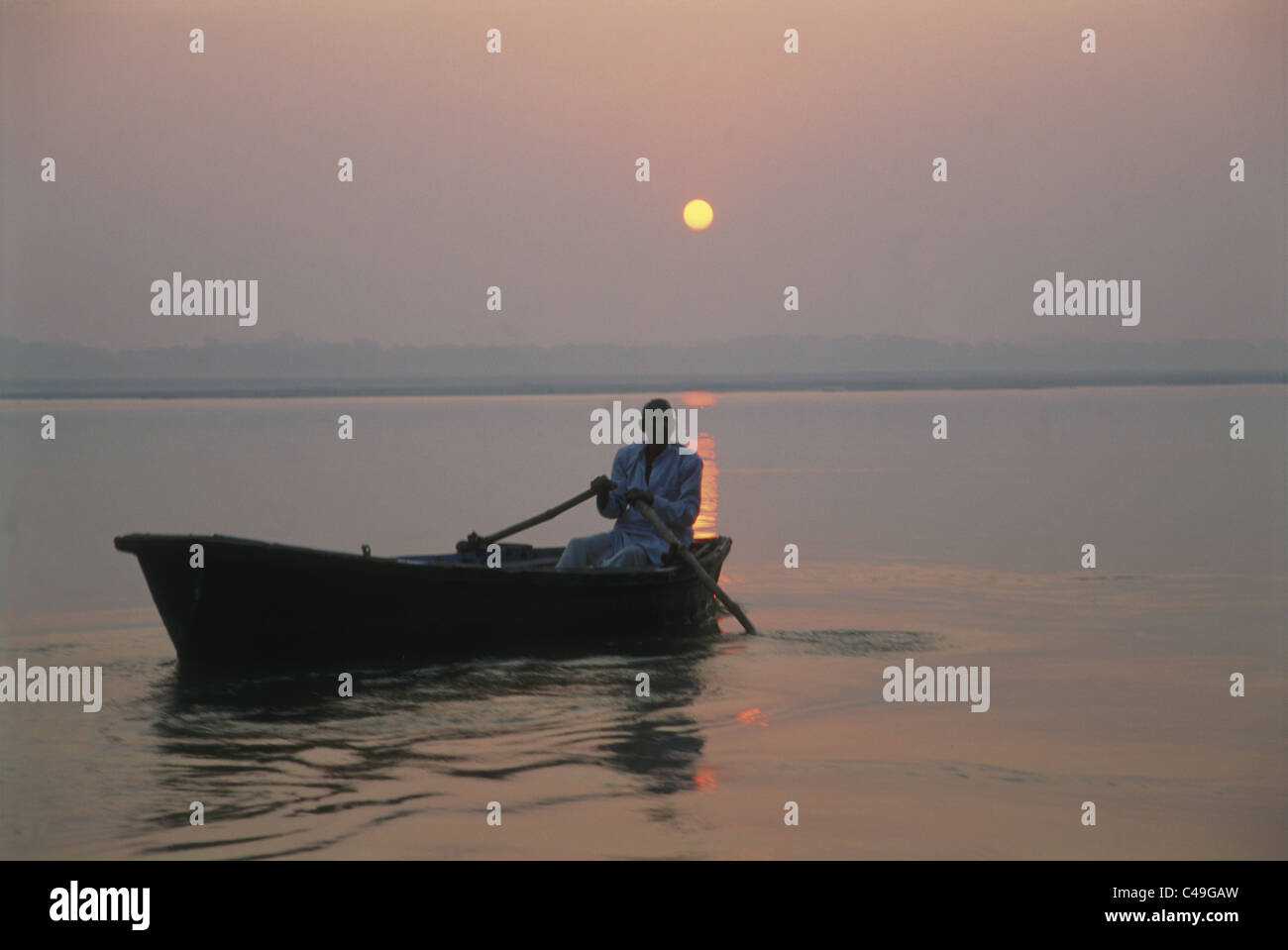 Fotografia di un uomo indiano remare una barca sul fiume in Varanasi India Foto Stock