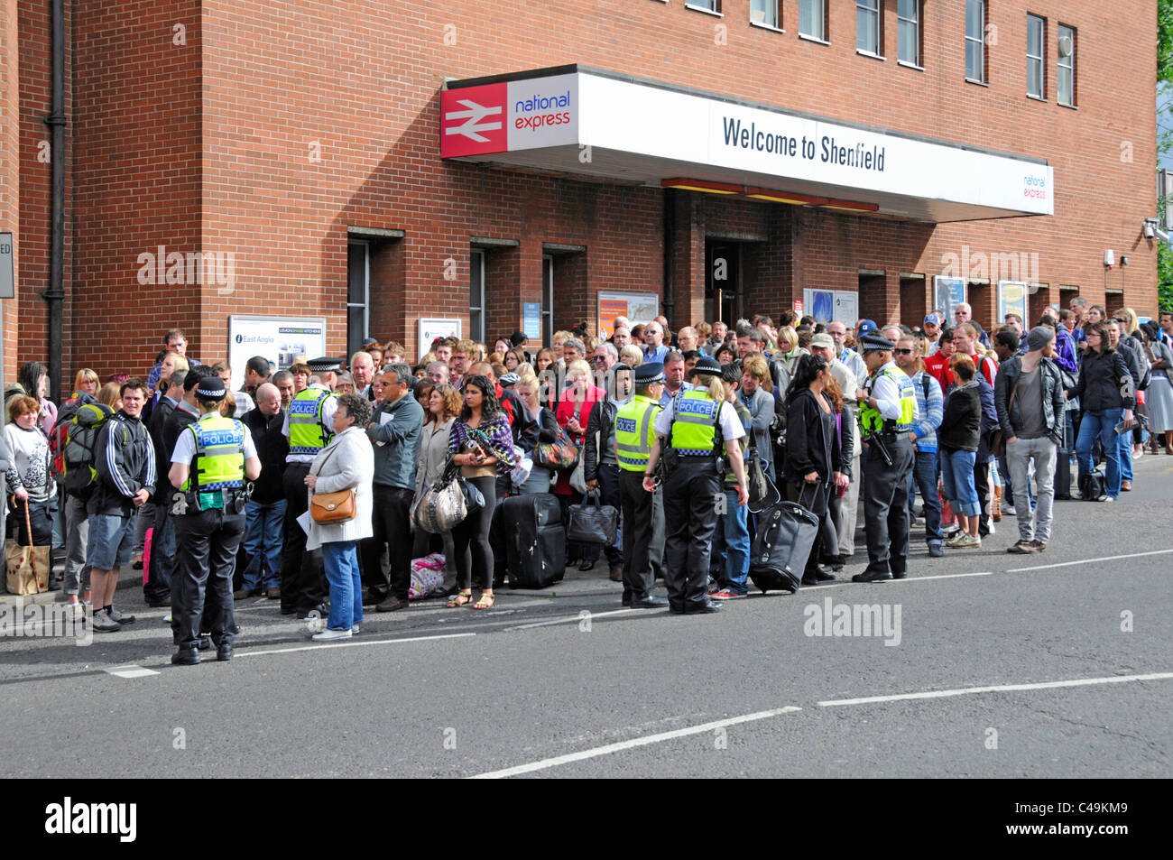 British Transport Police controllando la folla di persone al di fuori della stazione ferroviaria in attesa per gli autobus treno cancellazioni & guasto segnale Inghilterra Essex REGNO UNITO Foto Stock