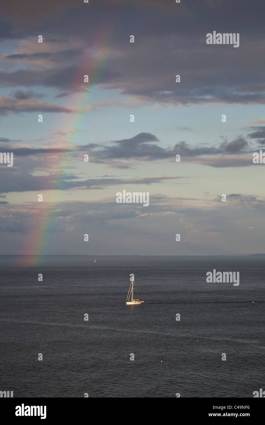 Barca a vela sul mare sotto il brillante arcobaleno colorato Foto Stock