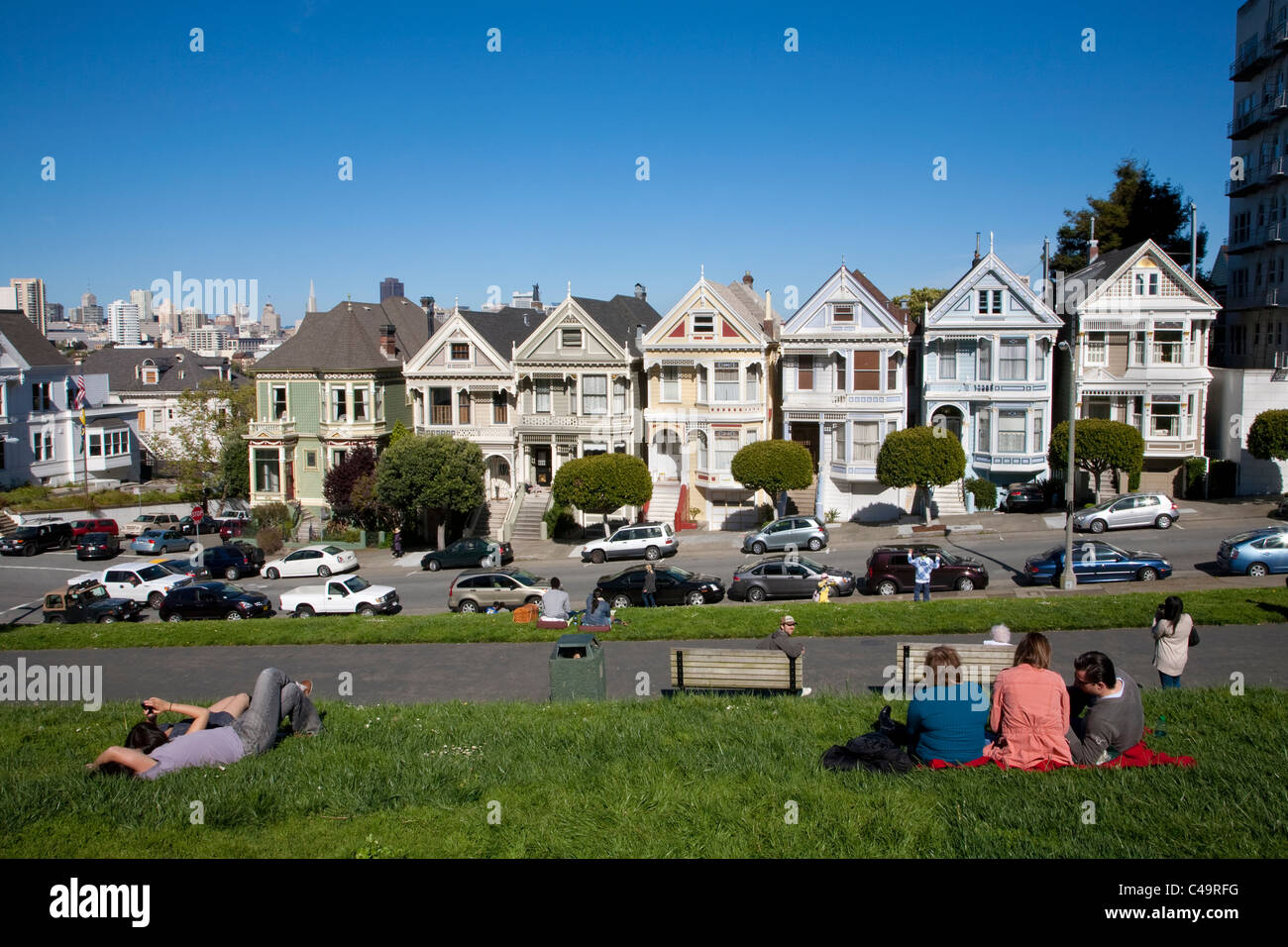 Cartolina di riga Painted Ladies case vittoriane attraverso da Alamo Square park su Steiner Street di San Francisco Foto Stock