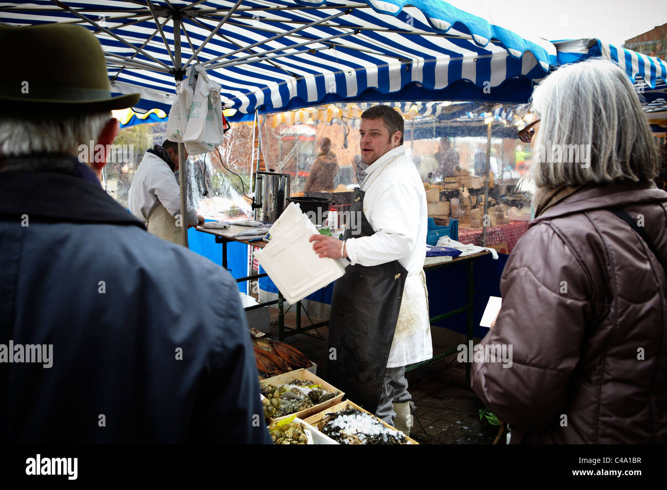 Un tradizionale pescivendolo sellsing pesce dal suo mercato in stallo a Londra Foto Stock