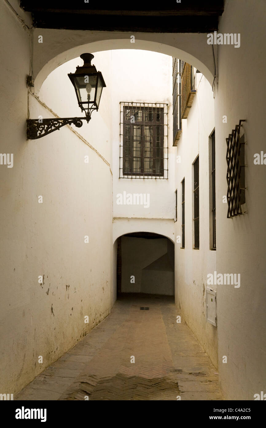 Tipica tradizionale / stretto passaggio chiuso / parzialmente coperto alley con illuminazione lanterna nel vecchio / centro di Siviglia. Spagna. Foto Stock