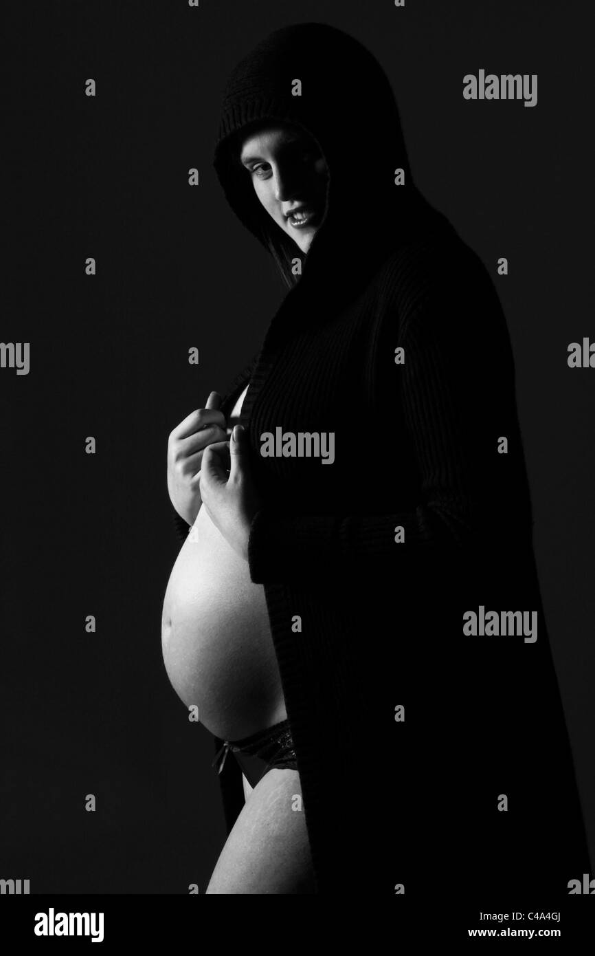 Creative in bianco e nero ritratto di una giovane donna incinta che è di nove mesi di gravidanza. Foto Stock
