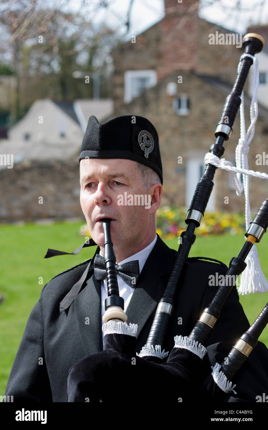 Un suonatore di cornamusa in umiform giocando le cornamuse nel nord dell'Inghilterra, all'aperto Foto Stock