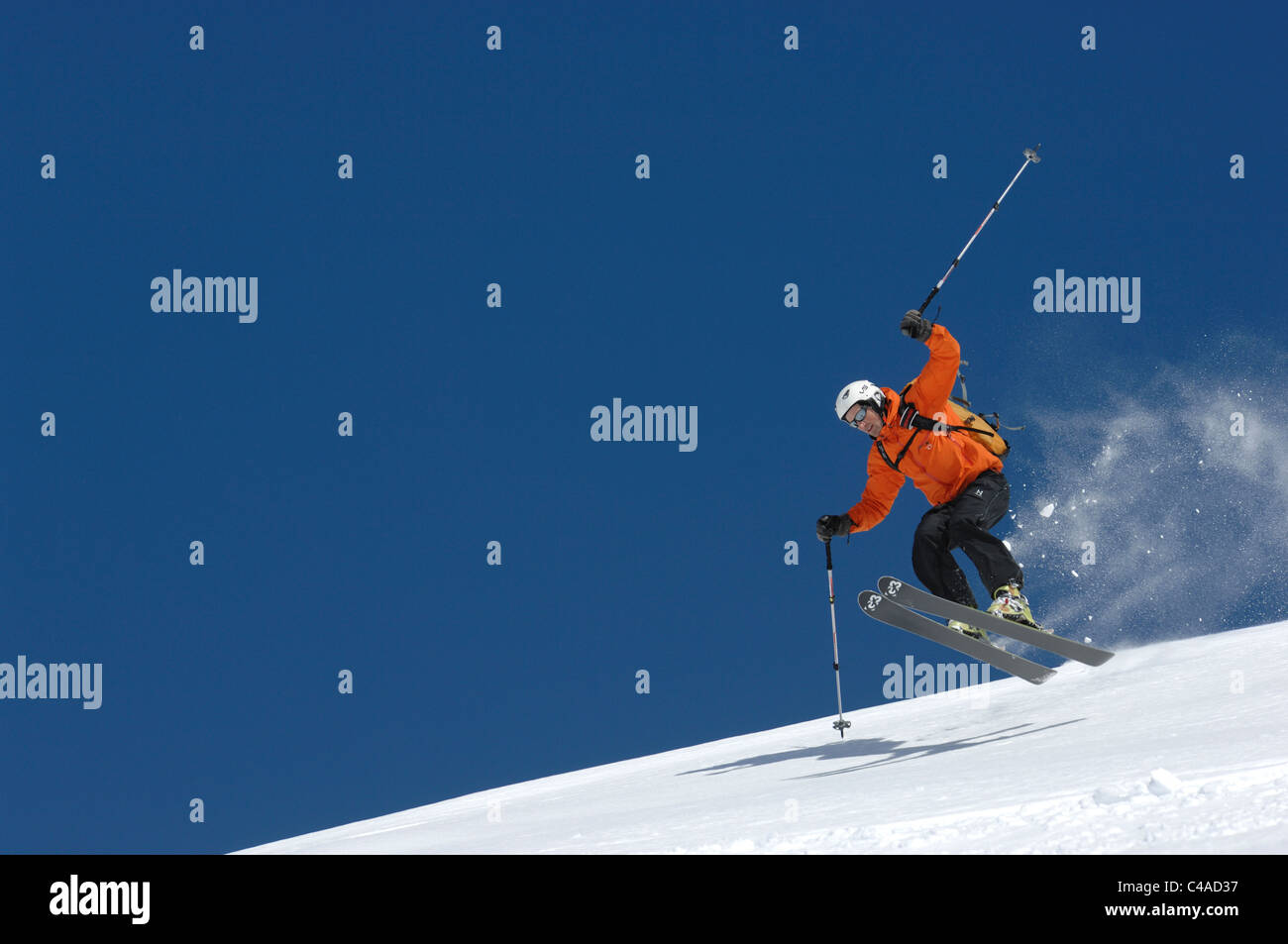 Un uomo sci di indossare un casco fuori pista in neve fresca sotto un cielo blu in Dizin resort parte delle montagne Alborz in Iran Foto Stock