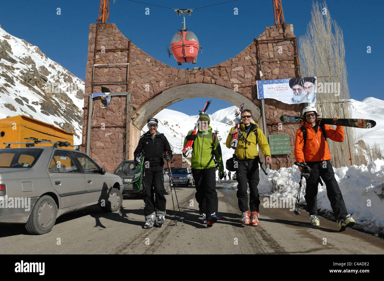Quattro uomini il trasporto di sci dopo una giornata di sci a Dizin nel Alborz montagne di Iran Foto Stock