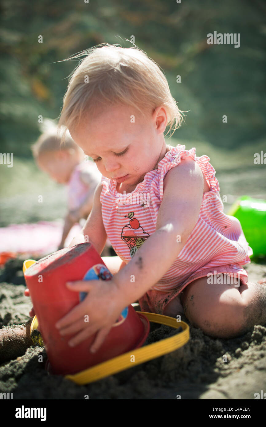 Bambini che giocano con i giocattoli di sabbia in spiaggia Foto Stock