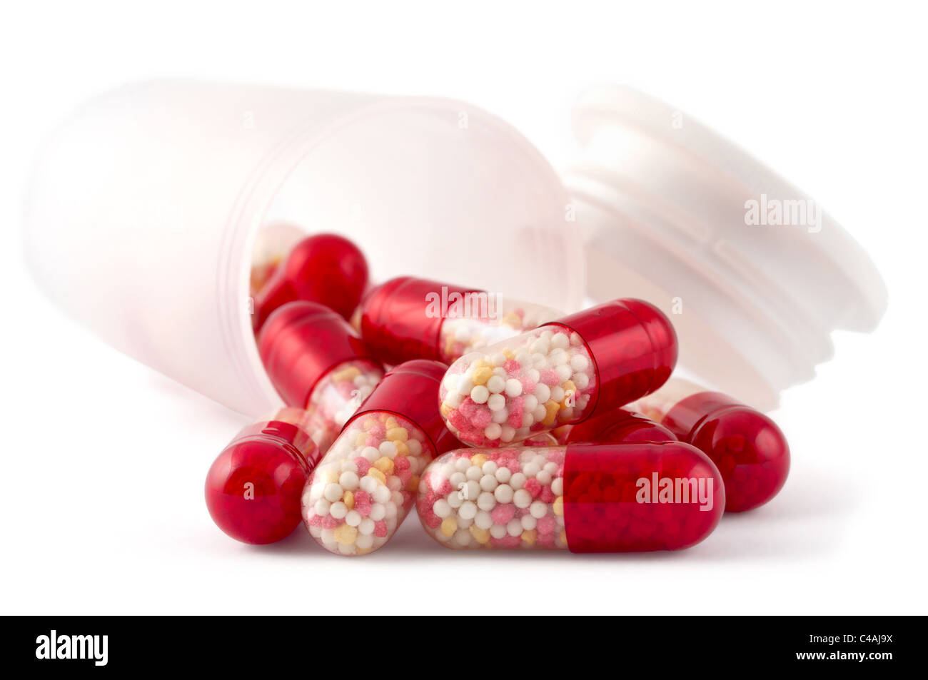 Pillole di rosso con bottiglia isolato su sfondo bianco Foto Stock