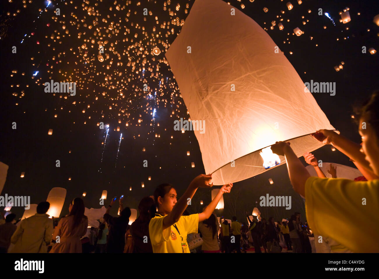 Thailandia Chiang Mai, San Isc. Lancio di festaioli khom loi (sky lanterns) nel cielo notturno durante il Yi Peng festival. Foto Stock