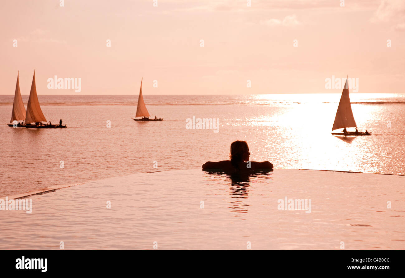 Zanzibar Matemwe Bungalows. Un turista sta al bordo di una piscina infinity a guardare il dhow. Il sig. Foto Stock
