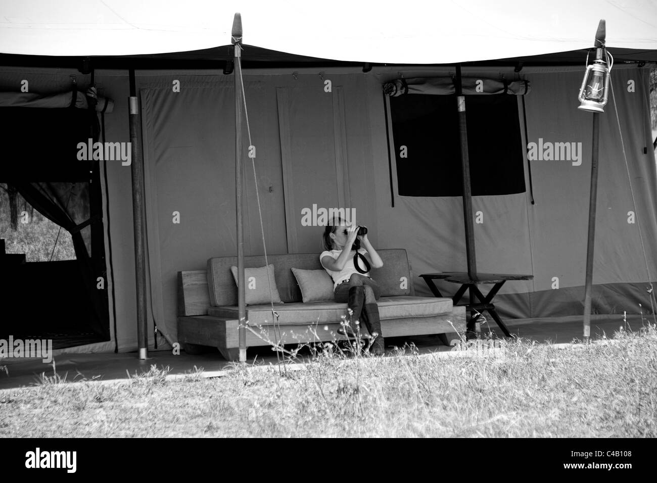 Tanzania, Serengeti. Una valutazione si affaccia sulla pianura dal comfort della sua tenda a Lemala Ewanjan. Il sig. Foto Stock