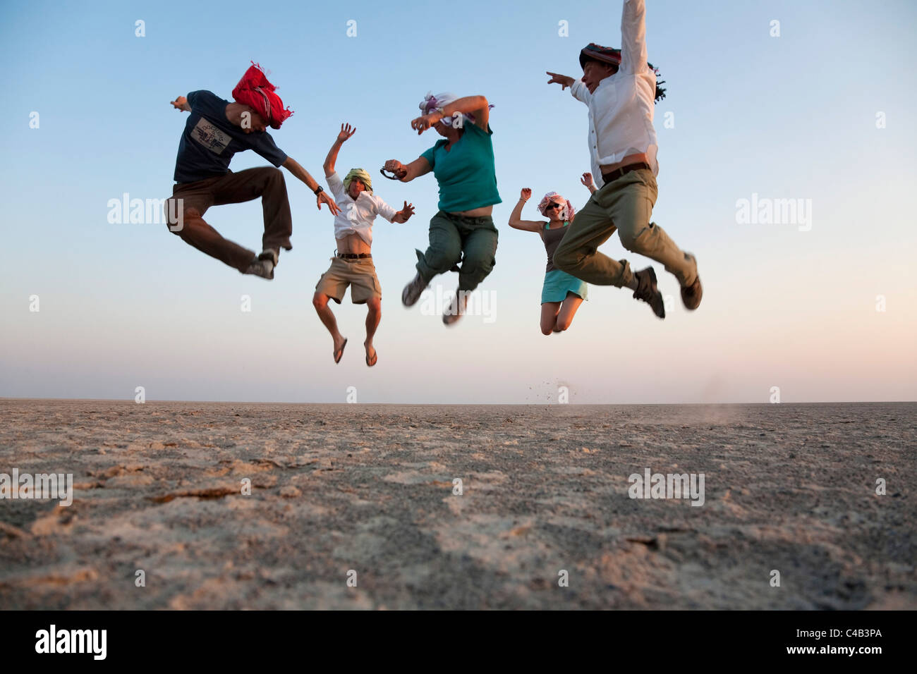 Il Botswana, Makgadikgadi. Una famiglia saltare in aria in alto al di sopra del Makgadikgadi saline. Il sig. Foto Stock