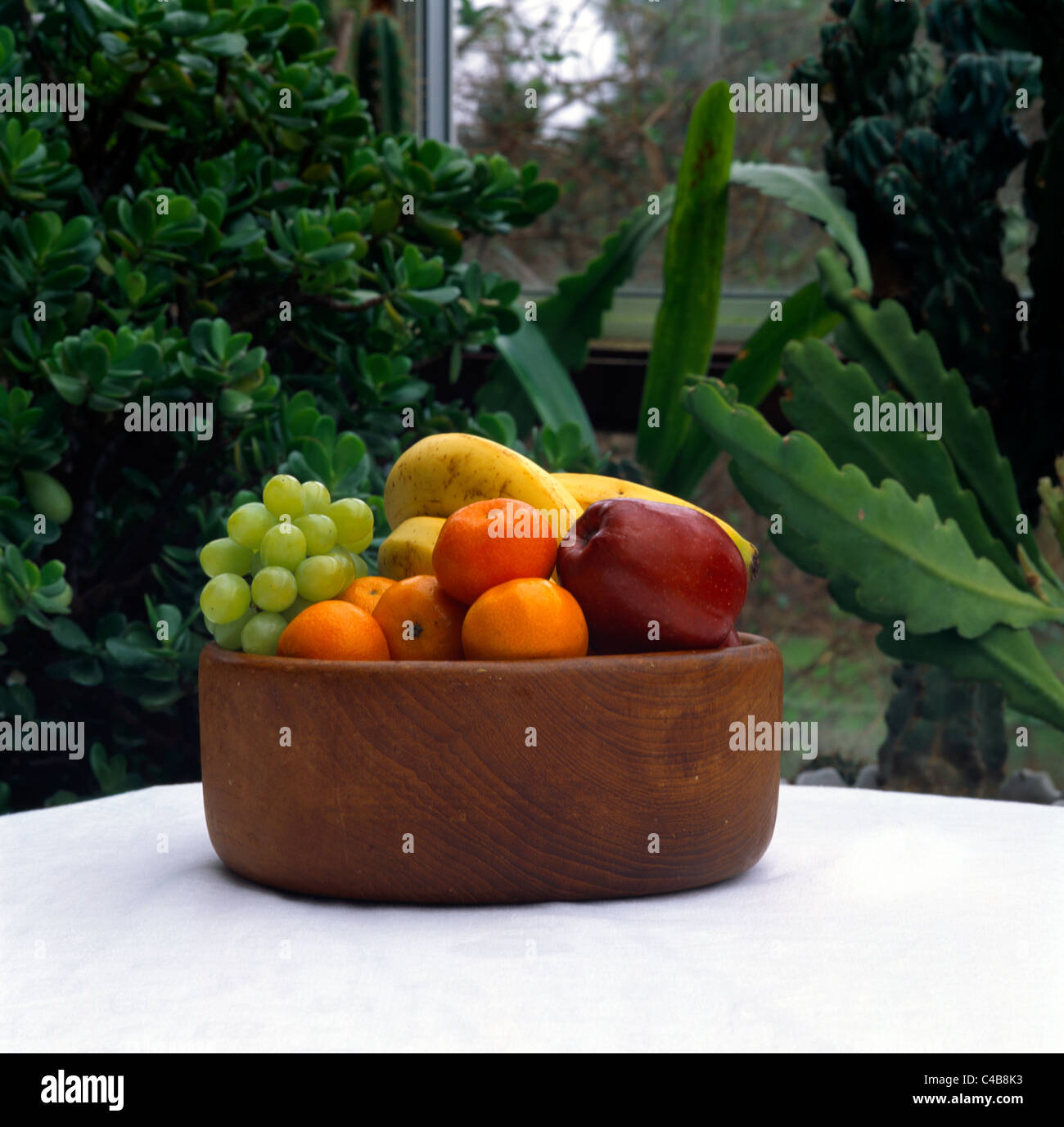 Frutta in legno ciotola riempita con frutta colore scialbo Foto Stock