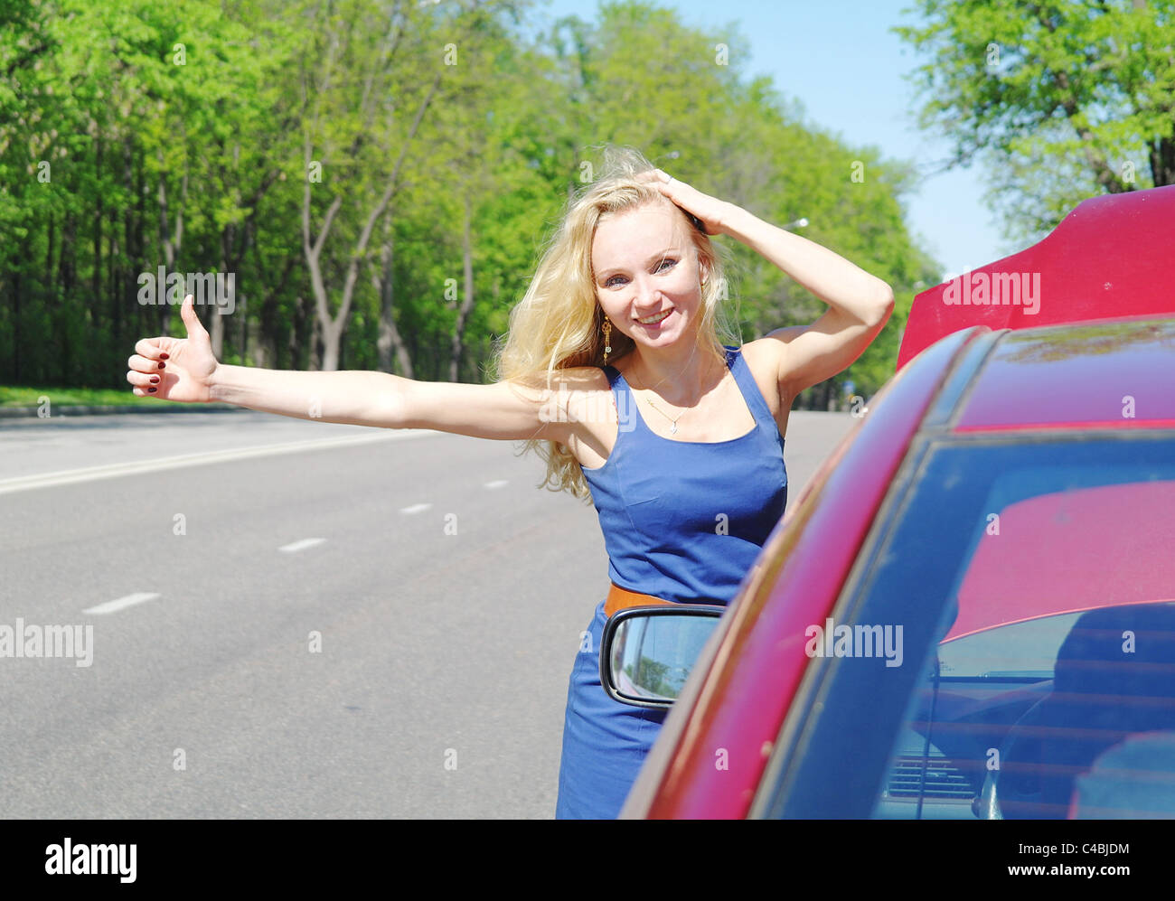 La ragazza bionda e voti circa l'auto rossa in estate, Mosca Foto Stock