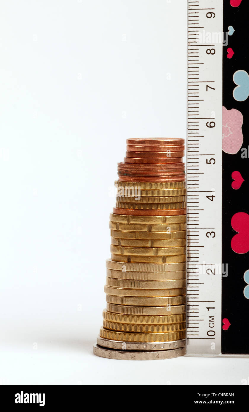 Pila di euro con un righello accanto per la loro misurazione Foto Stock Pila di euro con un righello accanto per la loro misurazione Foto Stock