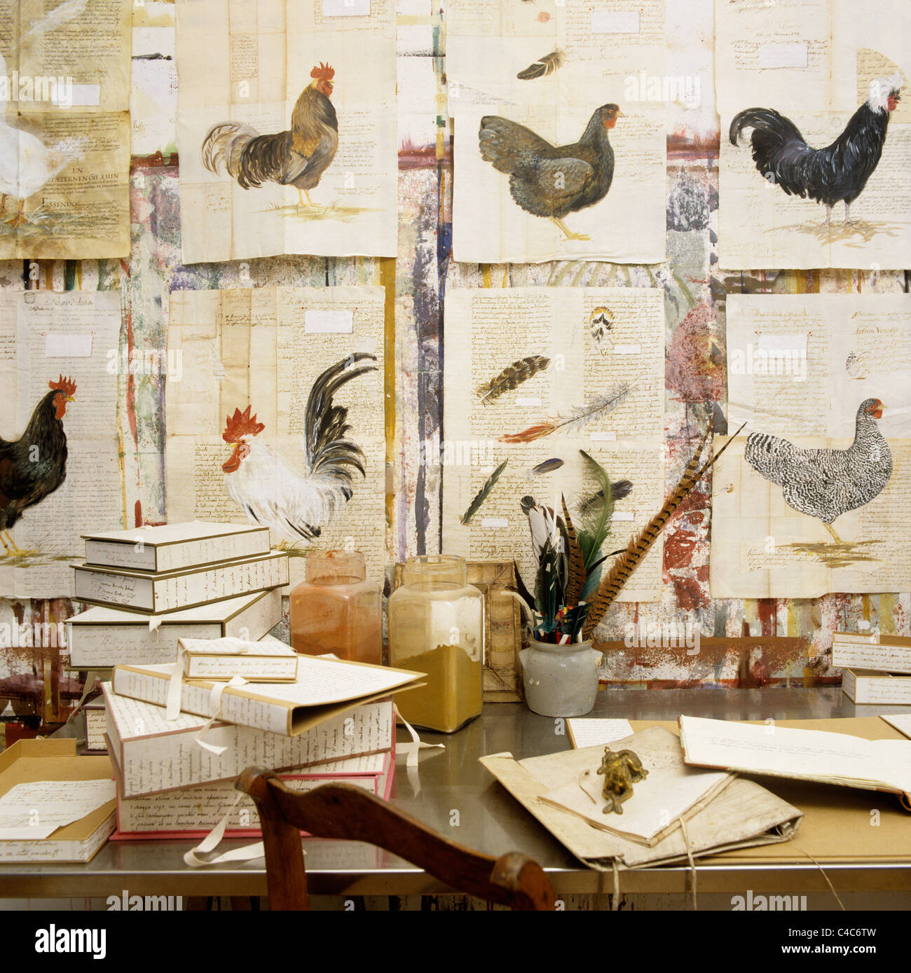Riga di acquerelli di galline sulla parete sopra tabella artisti Foto Stock