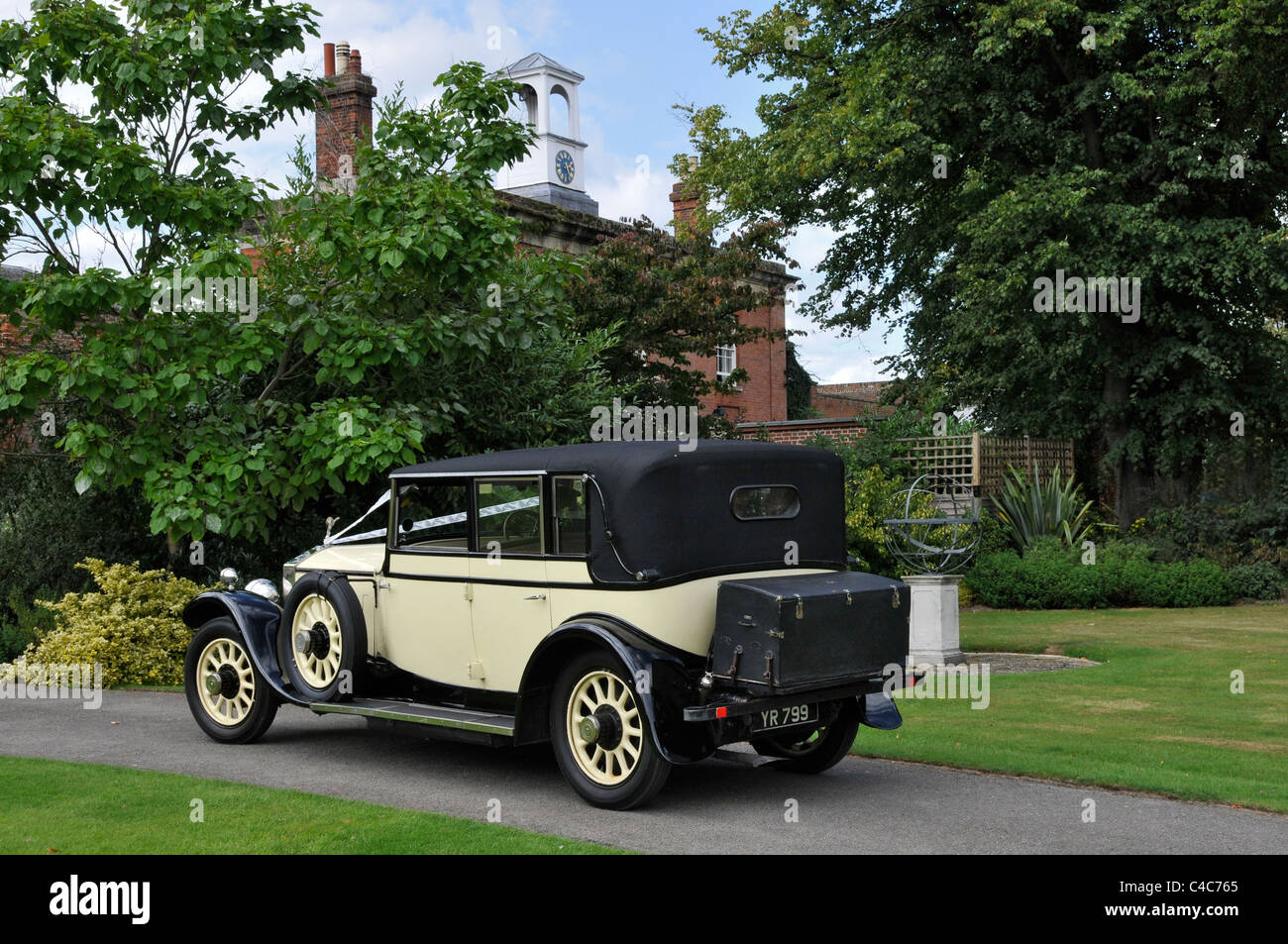 Un'attraente auto per matrimoni Rolls Royce vintage nera e crema parcheggiata sul drive di Cliveden con un campanile sul retro. Foto Stock